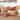Heavy fabric pink throw pillows scattered on a beige fabric sofa.