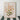 Framed floral artwork of orange blossoms with green leaves on tall stems, set in a slim gold frame