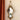 A Rococo vintage gold wall mirror with ornate detailing, hanging on a wall with a metal chain.