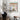 A colorful illustration canvas art of Singapore shophouse displayed on a wall above a wooden chair
